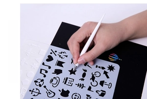 Detail of durable scratch art tool pen and plastic stencil with various shaped cutouts