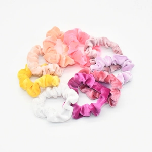 Close-up of assorted velvet scrunchies in vibrant colors like pink, purple, and orange
