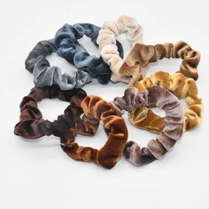 Set of 7 velvet scrunchies in vintage colors like beige and brown on white background