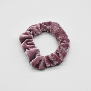 Close-up of velvet scrunchie in dark purple with detailed soft ribbed texture