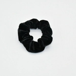 Detail of black velvet scrunchie with subtle glitter on a clean white background