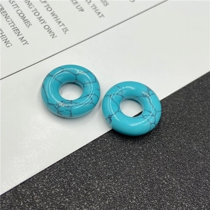 Macro detail of turquoise-colored natural stone beads with black marble patterns