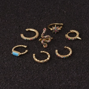 Set of seven gold U-shaped ear cuffs with colorful zircon and turquoise on black texture