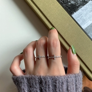 Close-up of 925 sterling silver cross rings with white zircon on woman fingers