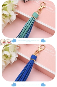 Detail of PU leather tassel keychain with gold lobster clasp in mint green and navy blue