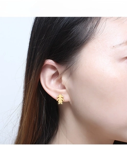 Close-up of golden silhouette girl stud earrings on model for minimalist fashion style