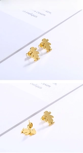 Detailed view of gold girl-shaped stud earrings with polished mirror finish and secure butterfly back