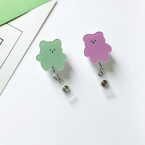 Detail of cute acrylic bear badge reels in pastel green and purple with secure metal snaps
