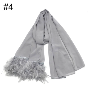 Primer plano de bufanda de gasa gris claro con detalles de plumas y textura suave