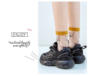 Close-up of mustard yellow ribbed cuff and cute cat pattern on transparent socks