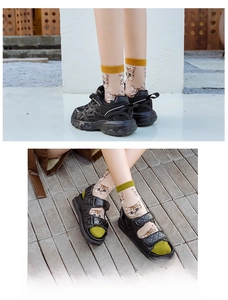 Detail of transparent mesh socks featuring cute cat patterns in yellow and green trims