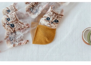 Detail of transparent mesh socks with brown tabby cat print and mustard yellow heel