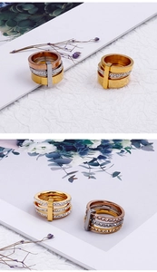 Macro detail of three-layer stacked rings with gold plating and cubic zirconia inlay