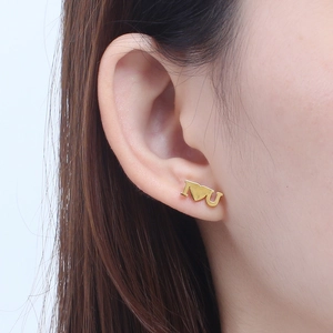 Golden titanium steel stud earrings with I heart U design shown on a model ear