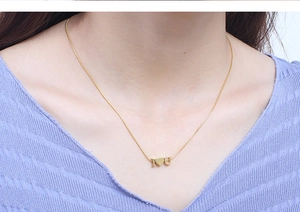 Close-up of gold snake chain necklace with I heart U pendant on female model neck