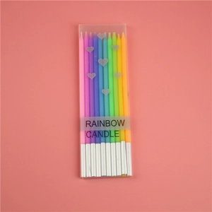 Macro detail of rainbow gradient birthday candles with silver bases in a heart box