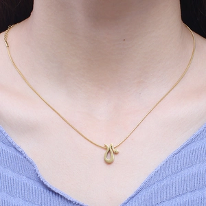 Minimalist gold snake pendant necklace for women shown on a model neck and collarbone