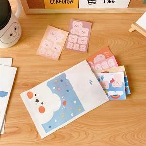 Close-up of cute cartoon bear stickers and mini envelopes on a cozy wooden desk setup