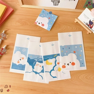 Detailed view of four mini paper bags with cute cartoon cloud bear prints on wood desk