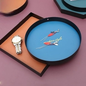 Detail of round and rectangular metal jewelry trays used for storing watches and accessories
