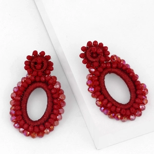 Handmade red beaded bohemian hoop earrings with festive circular design on white background