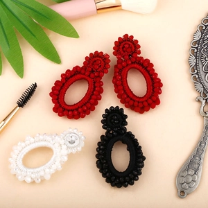 Detail of bohemian beaded drop earrings in red black and white handmade textures