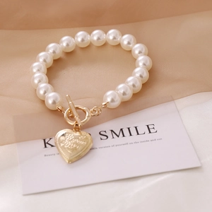 Macro view of vintage heart pendant and elegant pearl necklace with golden OT buckle closure