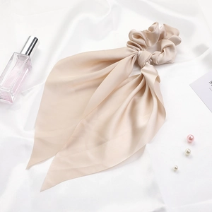 Elegant champagne satin scrunchie with long ribbons and smooth texture on silk fabric