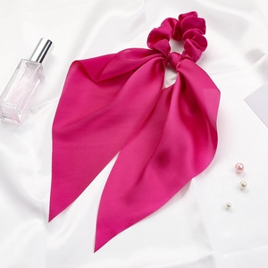 Detail of pink satin scrunchie with long ribbon streamers and smooth silky texture