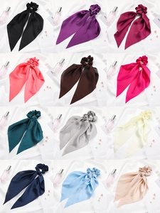 Flat lay of colorful satin hair scrunchies with long ribbons in twelve elegant shades