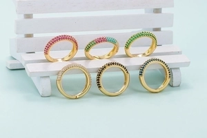 Set of six colorful zircon rings in gold plating with pavé setting on a white miniature bench
