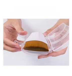 Detail of petal foundation brush being placed into its clear protective dust case