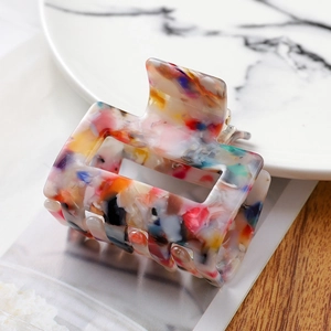 Detailed close-up of colorful acetate hair claw clip with a marbled terrazzo texture pattern