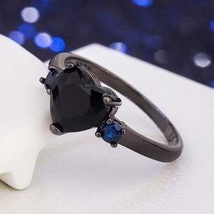 Fashion black heart-shaped ring with blue round side stones on a dark metal band