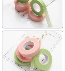 Breathable pink and green non-woven lash extension tape on a clean white desk
