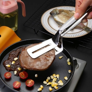 Macro shot of SUS 304 stainless steel food tongs flipping a steak in a kitchen pan