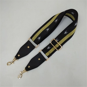 Detail of adjustable star pattern bag strap with gold metal hooks and sliding buckle