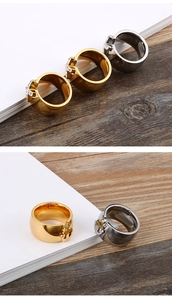Macro shot of anchor-shaped diamond rings in gold and silver on a wood surface
