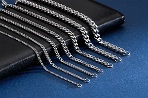 Multiple silver stainless steel flat curb chains in various widths on black leather background