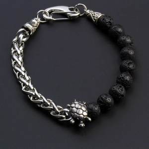 Detail of beaded men's bracelet with black lava stone, silver wheat chain and turtle charm