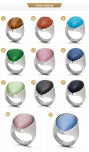 Multiple styles of titanium steel rings with teardrop gemstones in various colors