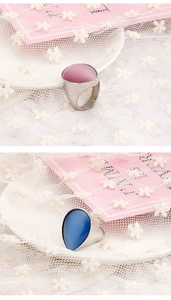 Detailed comparison of teardrop cat eye stone rings in pink and blue on lace background