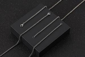 Detailed view of titanium steel O-chain with lobster clasp on a professional black stand