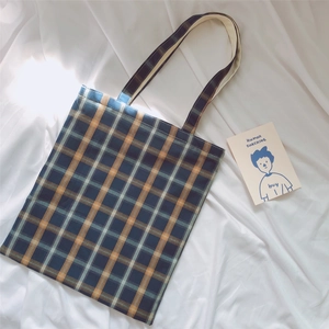 Detail of vintage plaid canvas tote bag in navy, yellow, and beige with dual straps