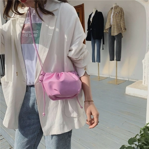 Close-up of pink ruched cloud bag with leather texture and thin shoulder strap detail