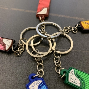 Detail of colorful PVC guitar pendants with intricate patterns and metal keychains