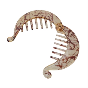 Detail of amber banana hair clip with marble pattern and interlocking resin teeth