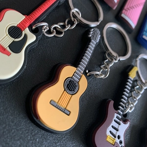 Detailed macro view of colorful PVC guitar keychains with metal rings on black background