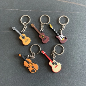 Flat lay of five colorful PVC soft rubber guitar and violin musical instrument keychains