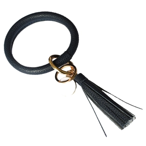 Detail of dark navy leather keychain ring with gold metal clasp and fringe tassels